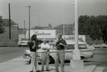Man with camera and others in parking lot, Farmville, Va., August 1963, #001