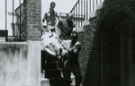 Woman being carried down steps on stretcher by police, Farmville, Va., July 1963