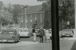 Man with camera and others in parking lot, Farmville, Va., August 1963, #004